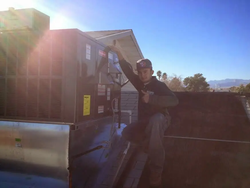 HVAC technician performing Heat Pump Repair on a rooftop unit in Crockett